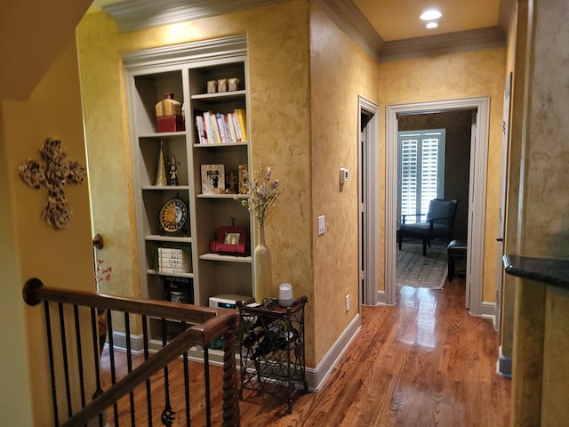 hallway with hardwood / wood-style floors, crown molding, and built in shelves