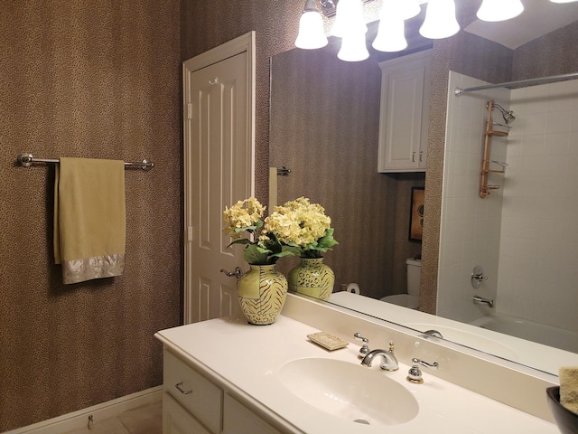 full bathroom featuring vanity, tiled shower / bath combo, and toilet