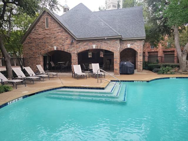 view of pool featuring a grill and a patio area