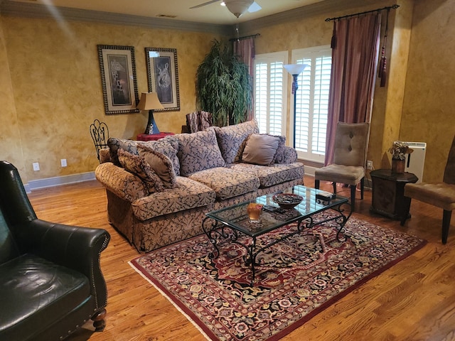 living room with ceiling fan, light wood-type flooring, and ornamental molding