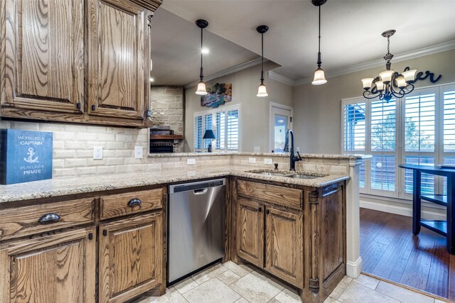 kitchen with sink, an inviting chandelier, light stone counters, appliances with stainless steel finishes, and ornamental molding