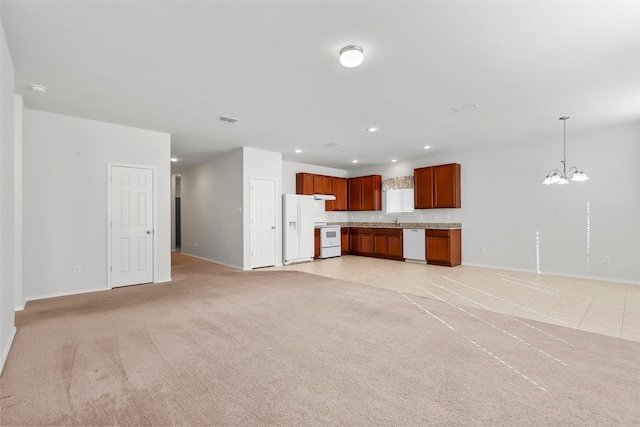 unfurnished living room with a chandelier, light tile patterned floors, and sink