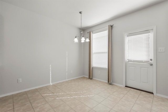 unfurnished room featuring a chandelier, light tile patterned flooring, and plenty of natural light