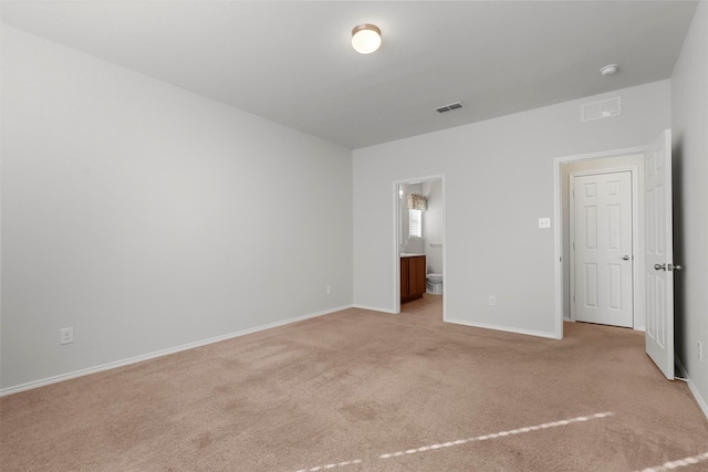 unfurnished bedroom with ensuite bath and light carpet