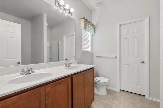 bathroom with toilet, vanity, and tile patterned flooring