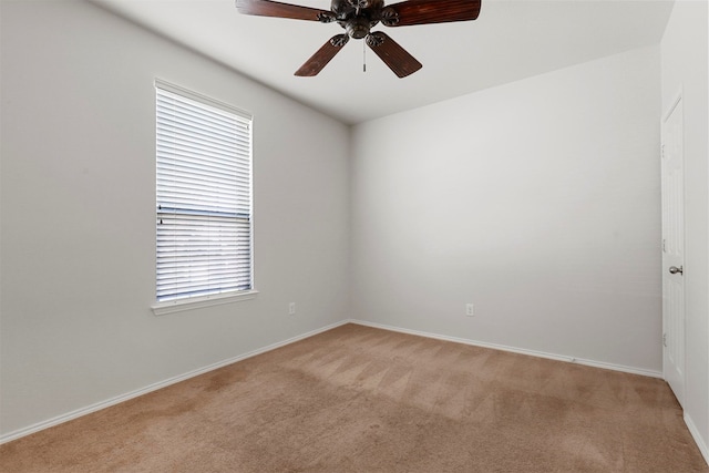 spare room with ceiling fan, light colored carpet, and plenty of natural light