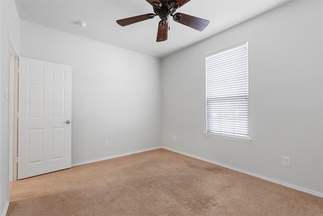 carpeted empty room with ceiling fan and plenty of natural light