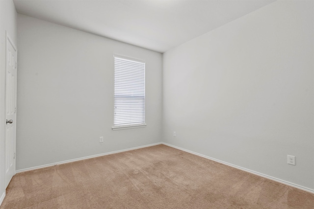 unfurnished room featuring light carpet