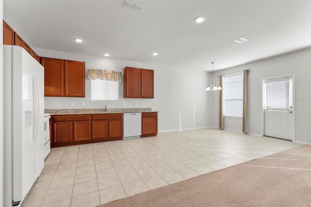 kitchen with hanging light fixtures, white appliances, a chandelier, and light carpet