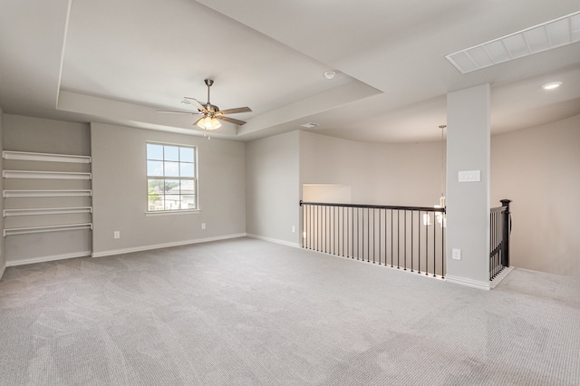 unfurnished room featuring light colored carpet, ceiling fan, and a tray ceiling