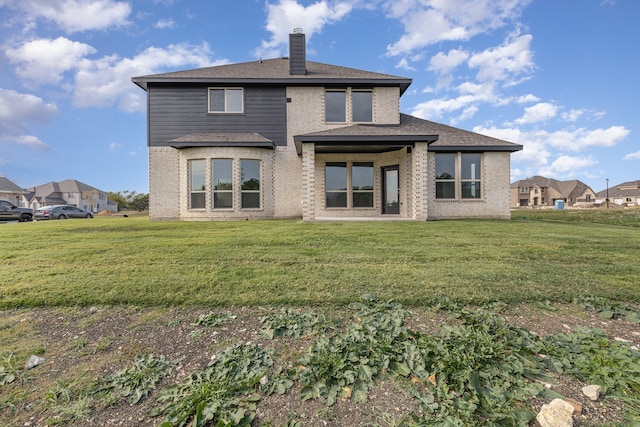 rear view of house featuring a lawn