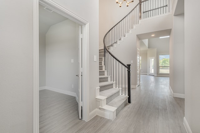 stairs featuring hardwood / wood-style floors and a high ceiling