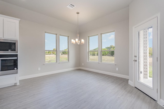 unfurnished dining area with light hardwood / wood-style flooring and an inviting chandelier