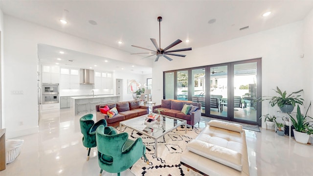 tiled living room with ceiling fan and sink