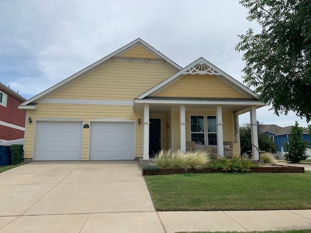 view of front of property with covered porch, a garage, and a front yard