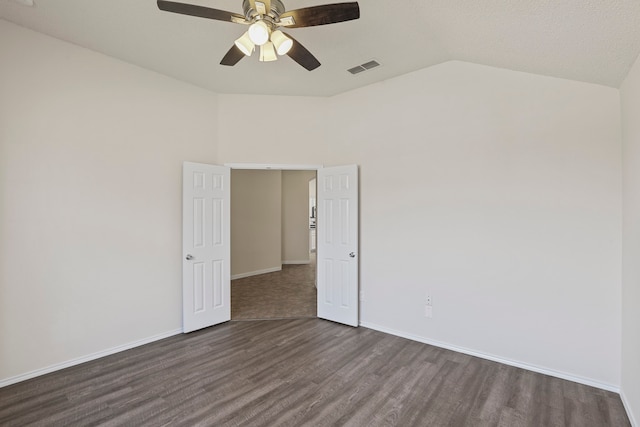 spare room with dark wood-type flooring, ceiling fan, a textured ceiling, and vaulted ceiling