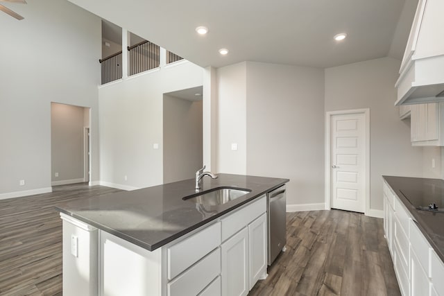 kitchen featuring dark wood-type flooring, a center island with sink, white cabinetry, sink, and dishwasher