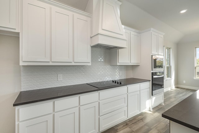 750 Serenity Ln, Red Oak, TX 75154 - kitchen featuring stainless steel appliances, dark countertops, custom exhaust hood, light wood-style flooring, and recessed lighting