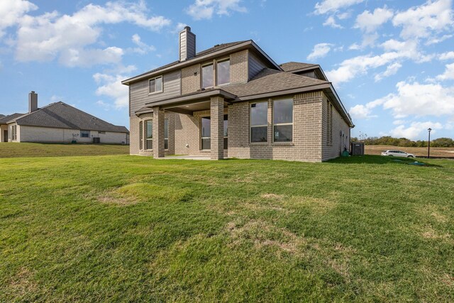 750 Serenity Ln, Red Oak, TX 75154 - back of house featuring brick siding, a chimney, a yard, and a shingled roof