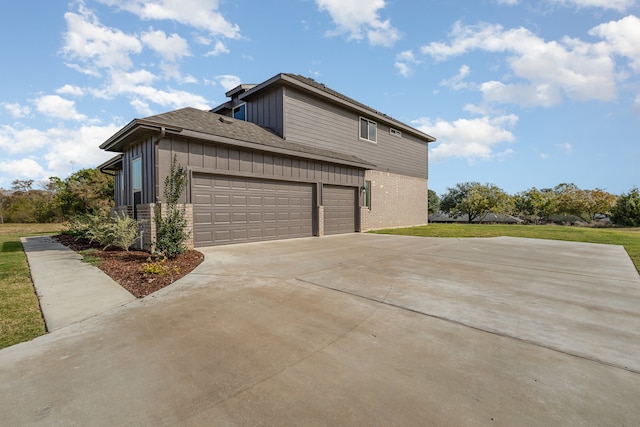 view of side of property featuring a lawn and a garage