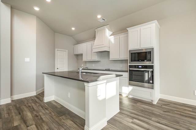 kitchen with stainless steel appliances, a center island with sink, sink, dark hardwood / wood-style floors, and white cabinets