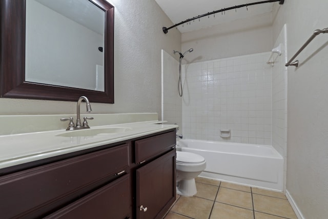 full bathroom featuring toilet, vanity, tiled shower / bath, and tile patterned flooring