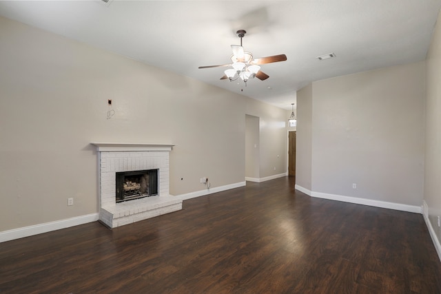 unfurnished living room featuring a fireplace, dark hardwood / wood-style floors, and ceiling fan