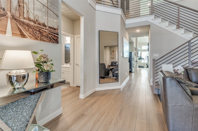 entrance foyer featuring a high ceiling, light wood-type flooring, and sink