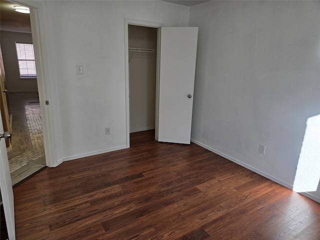 unfurnished bedroom featuring dark wood-type flooring and a closet