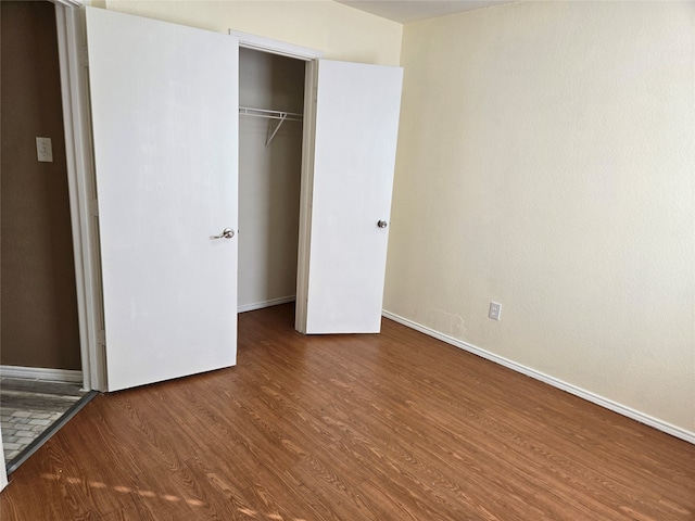 unfurnished bedroom featuring hardwood / wood-style flooring and a closet