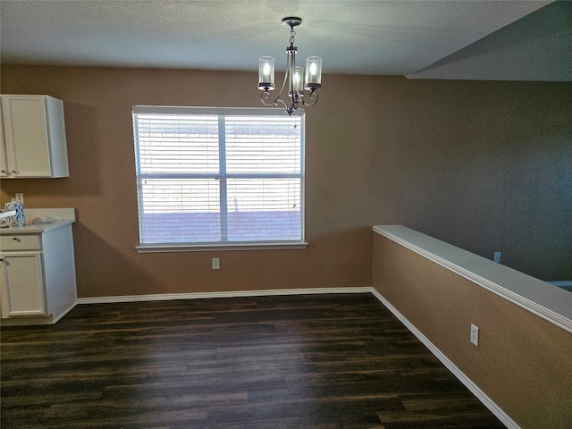 unfurnished dining area featuring a notable chandelier and dark hardwood / wood-style floors