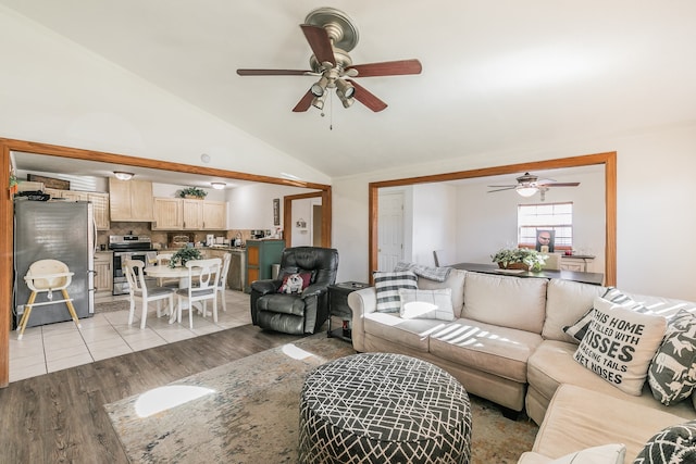 living room with ceiling fan, lofted ceiling, and light hardwood / wood-style floors