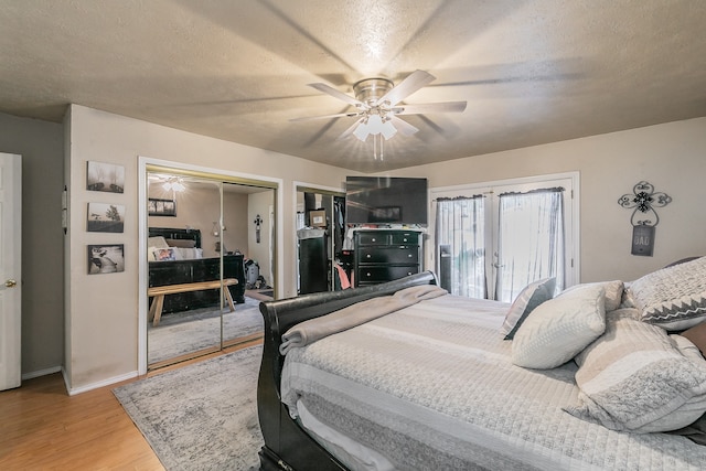 bedroom featuring french doors, a textured ceiling, ceiling fan, and light hardwood / wood-style flooring