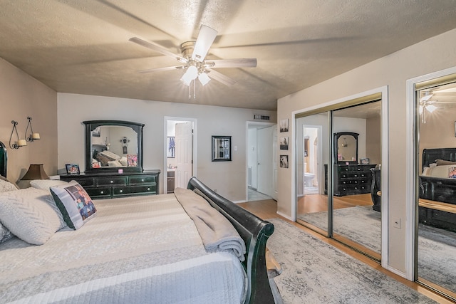 bedroom featuring connected bathroom, a textured ceiling, hardwood / wood-style flooring, and ceiling fan