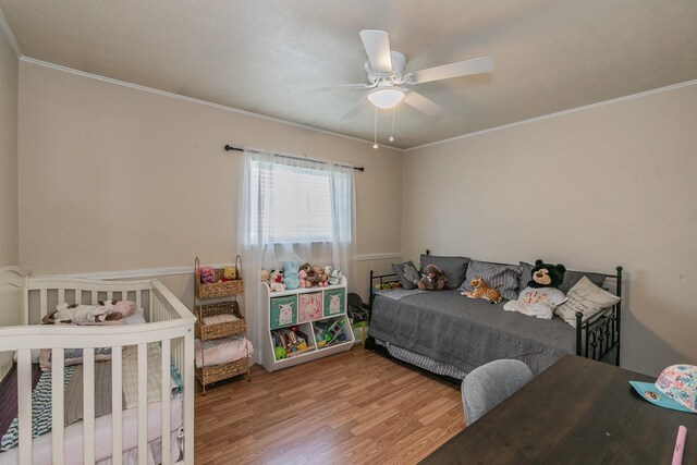 bedroom with ornamental molding, hardwood / wood-style floors, and ceiling fan