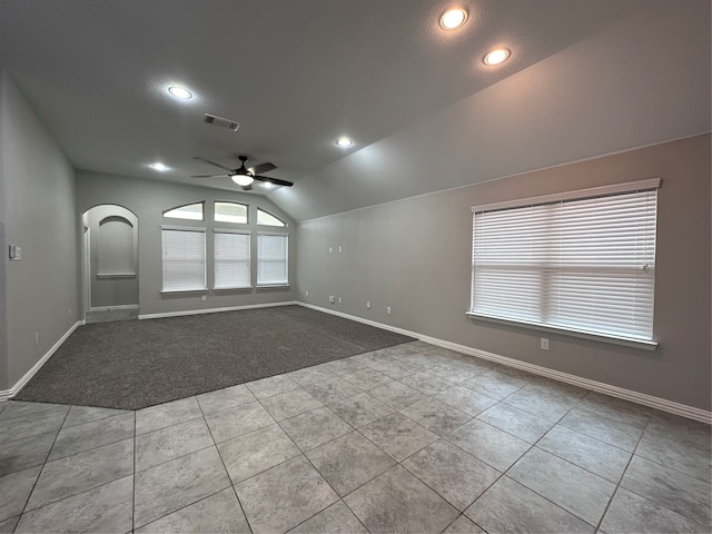 tiled empty room featuring lofted ceiling and ceiling fan