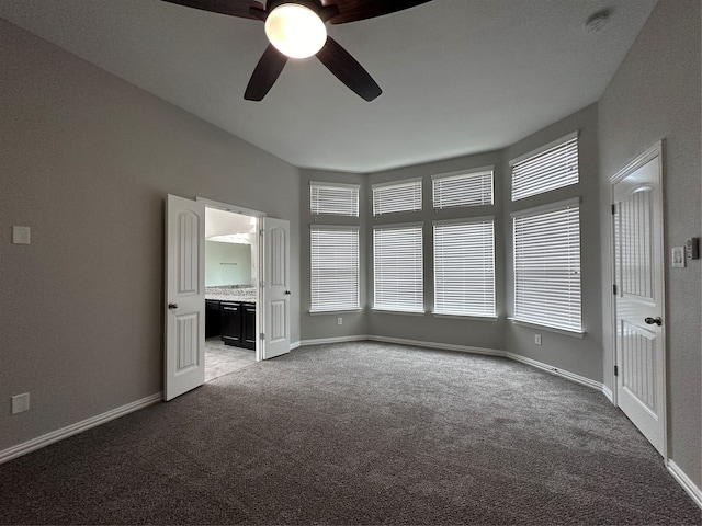 unfurnished bedroom with carpet floors, ceiling fan, and connected bathroom