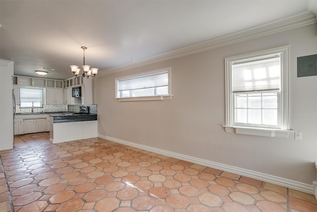 kitchen with white cabinetry, a notable chandelier, ornamental molding, and pendant lighting