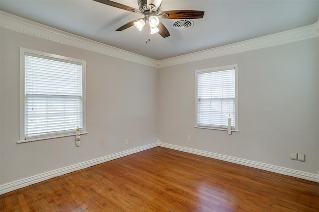 empty room featuring hardwood / wood-style flooring, crown molding, a healthy amount of sunlight, and ceiling fan