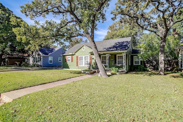2309 Honeysuckle Ave, Fort Worth, TX 76111 - view of front of house with a front yard, covered porch, and a shingled roof