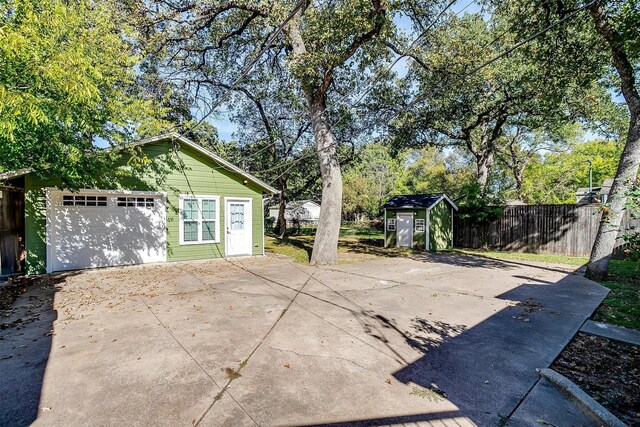 2309 Honeysuckle Ave, Fort Worth, TX 76111 - view of patio / terrace featuring fence, driveway, a storage shed, an outdoor structure, and a garage
