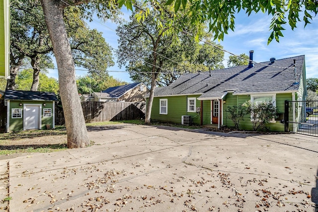 2309 Honeysuckle Ave, Fort Worth, TX 76111 - rear view of property featuring central AC unit, a shingled roof, and fence