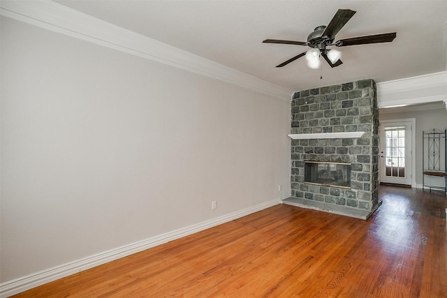 unfurnished living room featuring crown molding, wood-type flooring, ceiling fan, and a fireplace