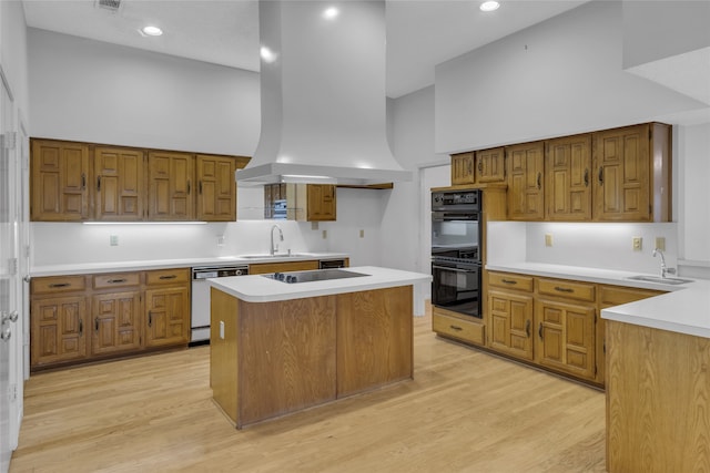 kitchen with black appliances, high vaulted ceiling, island exhaust hood, and a sink