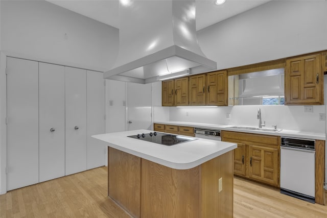 kitchen featuring light wood finished floors, a sink, white dishwasher, island range hood, and black electric cooktop