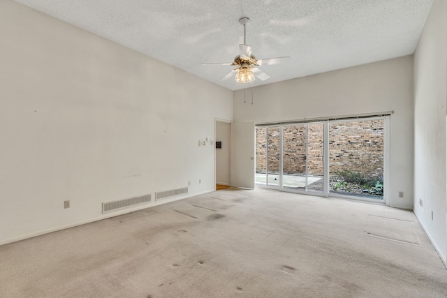 carpeted empty room featuring baseboards, visible vents, a textured ceiling, and ceiling fan