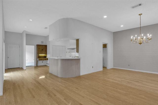 unfurnished living room with baseboards, visible vents, light wood finished floors, vaulted ceiling, and a chandelier