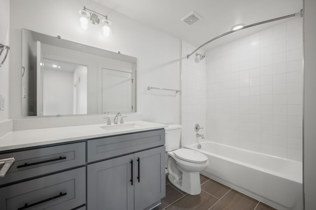 full bathroom featuring wood-type flooring, vanity, toilet, and tiled shower / bath