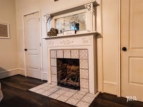 living room featuring hardwood / wood-style flooring and a tiled fireplace