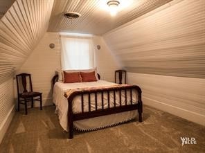 carpeted bedroom featuring lofted ceiling